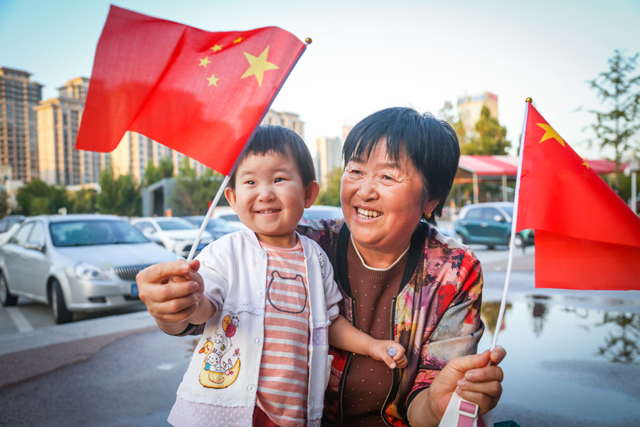 孩子开心地望着奶奶手里的五星红旗。田柏林(2039158)-20211001074217.jpg